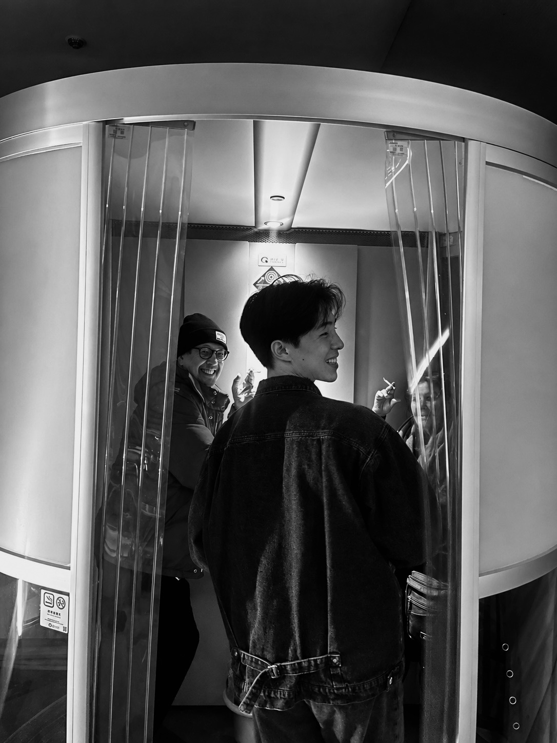 旅先のエレベーターで振り返る人物を写したモノクロ写真