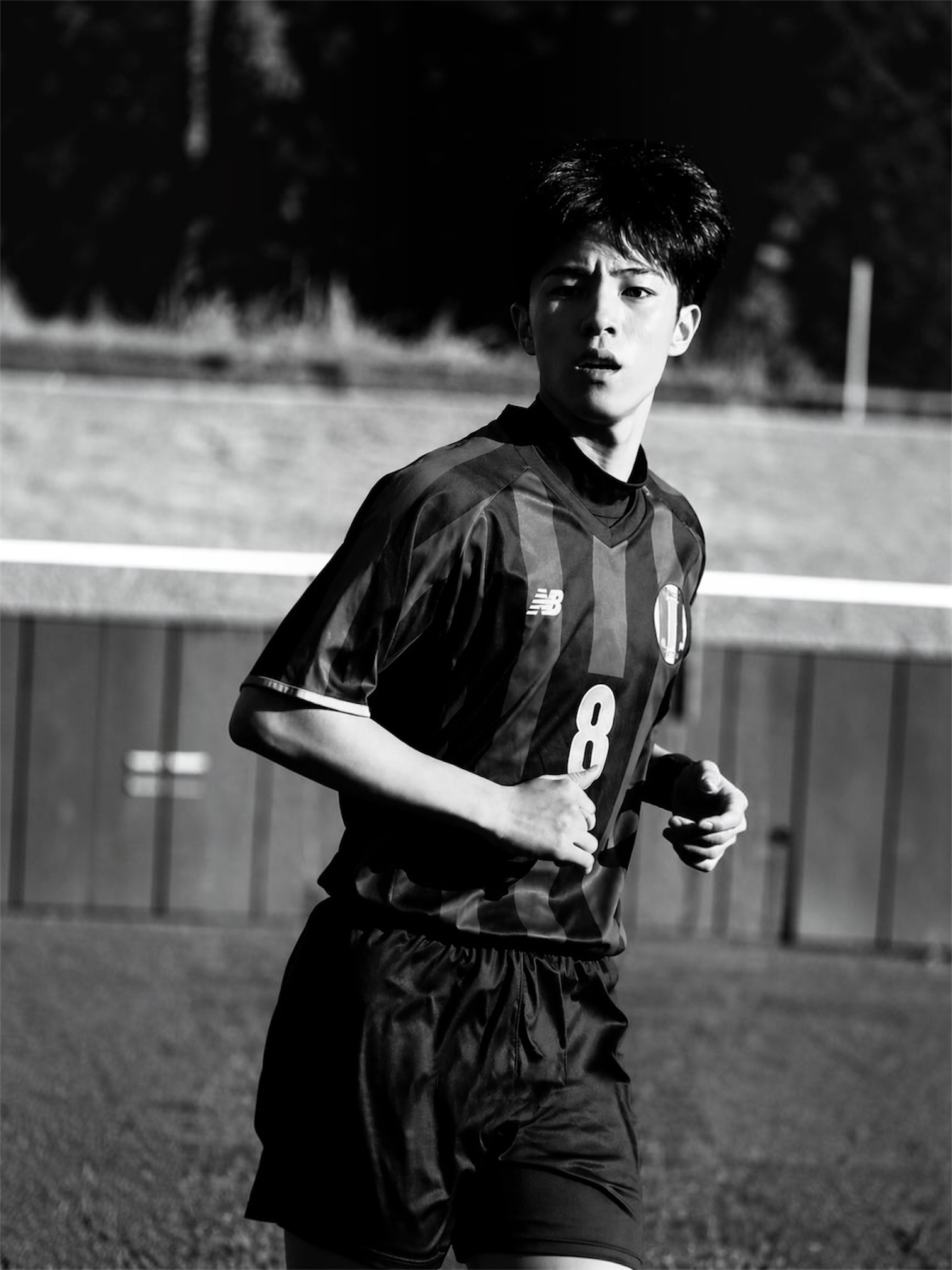 サッカーの試合中に走る人物のモノクロ写真